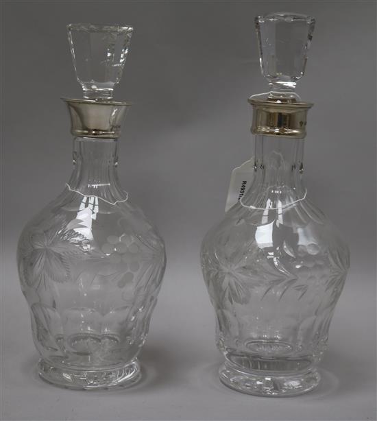 A pair of silver collared cut glass decanters, 29cm